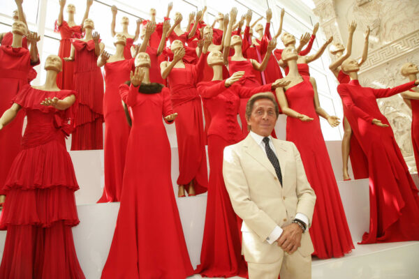 Elegant Valentino haute couture gown in signature Valentino red, showcasing intricate craftsmanship and timeless silhouette on a runway model