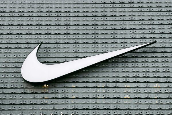 Nike quarterly earnings infographic showing $11.3B revenue, wholesale growth and margin pressure